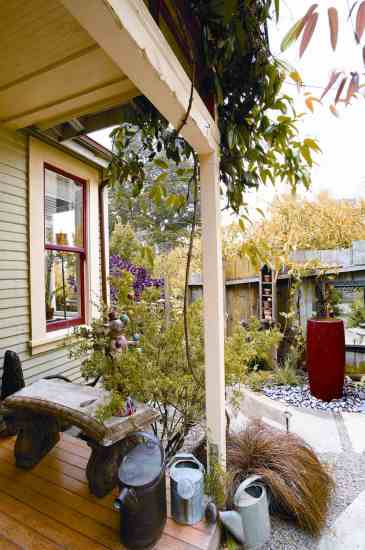 Alma displays a few of the watering cans from her extensive collection on her front porch.